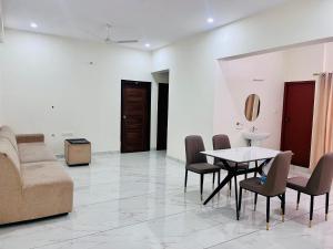 a living room with a couch and a table and chairs at Selfie Residency in Mysore