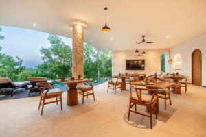 a dining room with tables and chairs and a fireplace at Villa Karilla in Toyapakeh