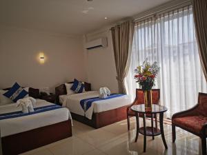 a hotel room with two beds and a table at Jun Yue Hotel in Phnom Penh +145 photos