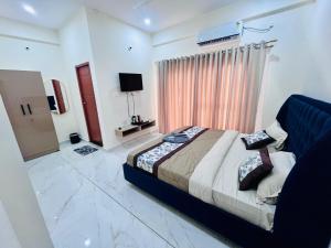 a bedroom with a bed and a television in it at Selfie Residency in Mysore