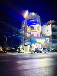 a building with cars parked in a parking lot at night at ANH VAN Motel in Chau Doc