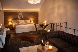 a bedroom with a bed and a couch and a table at Symbiose hotel in Charleroi