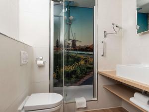 a bathroom with a shower and a toilet and a sink at Mercure Hotel Schiphol Terminal in Schiphol