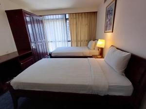 a hotel room with two beds and a window at Home Time Square Residence in Kuala Lumpur
