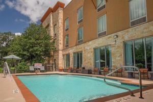 a swimming pool in front of a building at Hampton Inn Austin Oak Hill in Austin