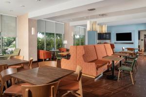 a restaurant with tables and chairs and a couch at Hampton Inn Austin Oak Hill in Austin