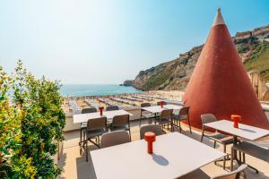 a view of the beach from a restaurant with tables and chairs at Alluz Nazare - Boutique Chalet By The Sea in Nazaré +147 photos