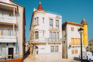 an old white building with a turret on a street at Alluz Nazare - Boutique Chalet By The Sea in Nazaré
