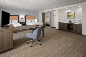 a hotel room with a bed and a desk and a television at Hampton Inn Dover in Dover