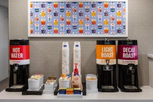 a kitchen counter with food and drinks and a light house poster at Hampton Inn Staunton in Staunton