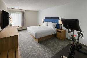 a hotel room with a bed and a flat screen tv at Hampton Inn Staunton in Staunton