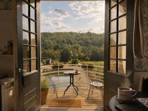 an open door to a balcony with a table and a view at Domaine de la Jasseix in Croze