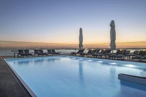 a large swimming pool with chairs and umbrellas at DoubleTree By Hilton Istanbul - Moda in Istanbul