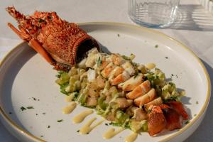 a plate of food with seafood and pasta on a table at Bellevue Sardinia Resort, Affiliated by Meliá in Valledoria +40 photos