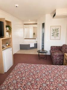 a living room with a couch and a bath tub at Peninsula Motor Inn in Tyabb