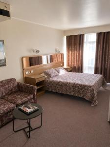 a hotel room with a bed and a couch at Peninsula Motor Inn in Tyabb