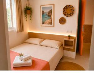 a small bedroom with a bed with towels on it at Emporda Llanca Guesthouse in Llança