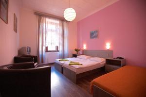 sypialnia z łóżkiem i różową ścianą w obiekcie Hotel Olga w Pradze