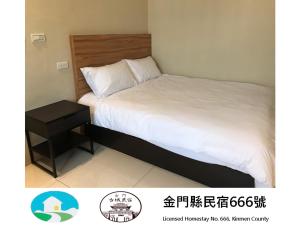 a bedroom with a bed and a nightstand next to it at Kinmen Old Town Homestay in Jincheng
