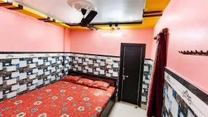 a bedroom with a bed in a room with pink walls at Hotel Protima guest inn in Digha
