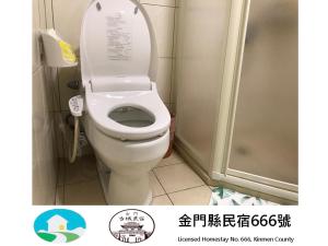 a bathroom with a toilet with the lid up at Kinmen Old Town Homestay in Jincheng +14 photos
