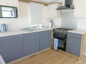 a kitchen with blue cabinets and a sink and a stove at Nova - Ukc9932 in Aston