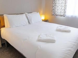 a white bed with two towels on top of it at Nova - Ukc9932 in Aston