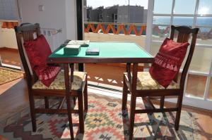Ericeira Beach Place في إيريسييرا: طاولة و كرسيين مع طاولة و نافذة