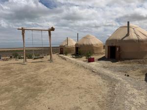 a group of three domes in the middle of the desert at Besqala Yurt Camp in Kabanbay