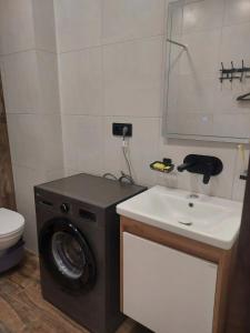 a bathroom with a washing machine and a sink at Студия у чистейшего Моря! in Gonio +8 photos