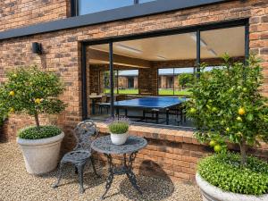 a patio with a table and chairs and a ping pong table at Peninsula Motor Inn in Tyabb
