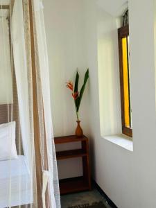 a plant in a vase on a table next to a window at La Olive Villa  +5 photos