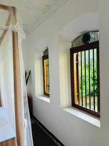 an empty room with two windows in a house at La Olive Villa 