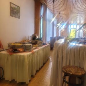 a row of tables with white table skirts at Ezüstfenyő Üdülő Visegrád in Visegrád +13 photos