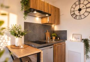 a kitchen with a sink and a clock on the wall at Magic Disney 5mn Peaceful Home Garden Parking in Chessy