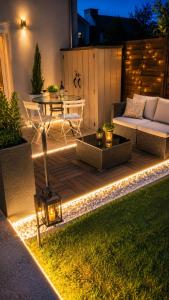 a patio with a couch and a table with lights at Magic Disney 5mn Peaceful Home Garden Parking in Chessy