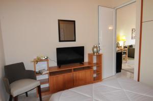 カラモスにあるRossa 18のベッドルーム(テレビ、椅子、ベッド付)
