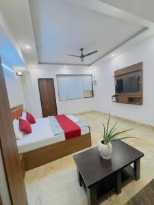a bedroom with a bed and a table in it at Hotel Shankara Inn in Ayodhya