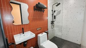 a bathroom with a toilet and a sink and a mirror at Asthaloka Bed & Chill Pasteur in Bandung +69 photos