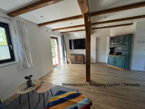 a living room with a table and a kitchen at Brokeloh - Hier bin ich zuhause ! in Landesbergen
