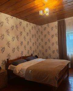 a bedroom with a bed and a wooden ceiling at Guest House in Zhabeshi Lali in Zhabeshi