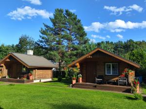 a log cabin with a porch and a lawn at Katase Guest House in Katase