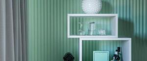 a green wall with a shelf with glasses and a vase at COMO Metropolitan Miami Beach in Miami Beach