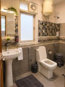 a bathroom with a toilet and a sink and a window at Lime Tree Haven in Kulu
