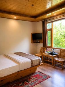 a bedroom with a bed and a desk and a window at Lime Tree Haven in Kulu