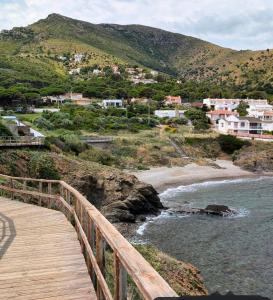 a wooden bridge over a body of water with houses at Emporda Llanca Guesthouse in Llança +14 photos