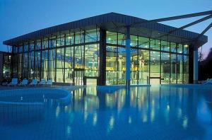 a large glass building with chairs in front of it at Vinea Apartma in Gornja Radgona