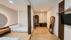 a room with two beds and a tv and a mirror at Asthaloka Bed & Chill Pasteur in Bandung