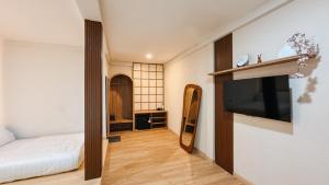 a bedroom with a bed and a flat screen tv at Asthaloka Bed & Chill Pasteur in Bandung