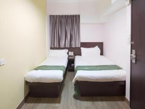 a hotel room with two beds and a window at Metroplace Olympic in Hong Kong